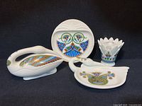 Four ceramic items from Elizabeth Arden Treasures of the Pharaohs collection, showing front and detail of all pieces with black background.