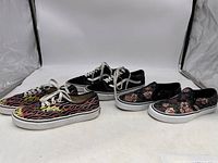 Three pairs of Vans sneakers displayed: flame patterned men's size 5, black and white men's size 8, and floral print women's size 6.5 slip-ons.
