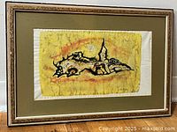 Framed watercolour painting showing abstract imagery in yellow, orange and black with olive green matte and ornate beige frame