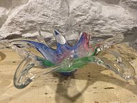 Angle view of the glass bowl showing multi-color swirled center with clear sculptural extensions