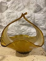 Front photo of large amber Lorraine glass decorative bowl showing open, curved top and rounded base.