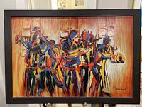 Frontal photo of the framed oil painting showing five abstract jazz musicians with vibrant colors.
