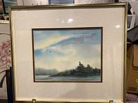 Framed watercolour painting showing landscape with birds and trees under a sky with soft color gradient.