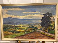 Full view of framed oil painting showing landscape with road, trees, and distant hills under a clouded sky.