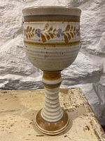 Front view of the tall ceramic goblet showing decorative leaf band and ribbed stem