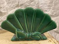 Front view of vintage ceramic planter modeled as an Art Deco fan with bow, green glaze.