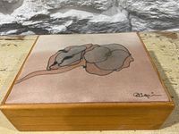 Top view of the vintage jewelry box showing the velvet lid with floral design and signature.