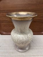 Photo of ceramic vase showing bulbous body and flared rim with gold accent.