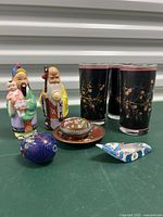 Full lot showing figurines, glasses, decorative plate with lidded box, and blue cloisonné egg