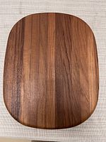 Top view showing natural teak wood grain and rounded edges of cutting board.