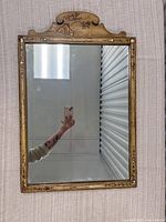 Full front view of the rectangular wooden framed mirror showing the reflective surface and overall condition.