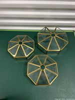 Top view of three stacked brass and glass octagonal light fixtures showing shape and condition