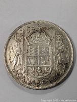 Front side of 1940 Canada silver half dollar coin showing shield, crown, lion, unicorn and inscriptions.