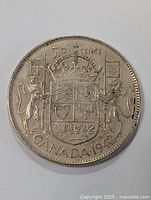 Close-up of 1942 Canadian 50 cent silver coin featuring detailed coat of arms and crown.