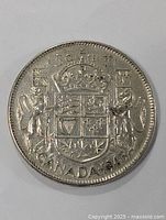 Front view of the 1945 Canada silver half dollar coin showing detailed coat of arms and denomination