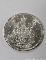 Close-up image of the front side of a 1960 Canadian 50 cents silver coin showing the detailed coat of arms and inscription.
