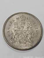 Obverse view of the 1961 Canadian 50 cent silver coin showing the coat of arms, date and denomination.