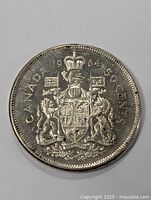Obverse side of the 1964 Canadian 50 cents silver coin showing the Canadian coat of arms in good vintage condition.
