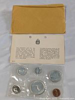 Photo showing the complete 1967 Canadian silver coin set sealed in original plastic packaging with the protective document and envelope.