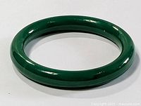 Full top view of deep green jade bangle showing smooth polished surface and round shape.