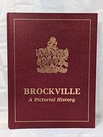 Front cover of the Brockville A Pictorial History book showing burgundy leather-like material with gold embossing including a crest and title.