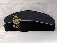 Side view of the blue and black RCAF side cap hat showing the 420 Squadron insignia and numbering.