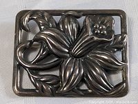 Front view of the rectangular Danecraft sterling silver floral brooch showing detailed petals and leaves in raised design with natural patina.