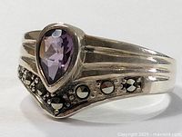 Close-up image of the sterling silver ring featuring the pear-shaped amethyst and marcasite accents from an angled perspective.