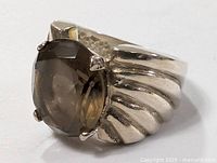 Close-up angle of sterling silver ring with large faceted smoky quartz stone and ribbed band