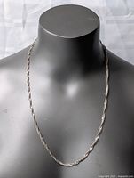 Full view of the sterling silver necklace displayed on the mannequin, highlighting length and overall shape.