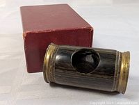 Side angle spy glass showing wood and brass materials beside the box.