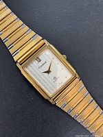 Front view of vintage men's Cardinal quartz watch showing rectangular case, dial, and two-tone bracelet.