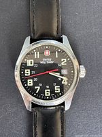 Close up front view of watch face showing brand, time, date and second hand.