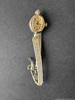 Full view of the vintage women's Cardinal watch showing the gold-tone mesh band, oval watch face with ridged bezel, and winding crown.