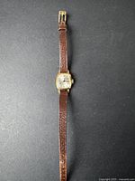 Full view of the vintage Cardinal women's wristwatch showing the entire brown leather strap and gold-tone rectangular watch case.