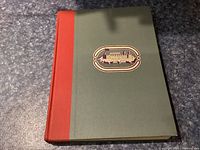 Front cover of Forts of Canada book showing green cover with red spine and a gold foil illustration of a fort.