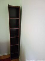 Full view of tall narrow corner bookcase showing six shelf sections