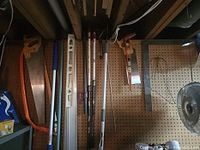 Group view of saws, level, poles on pegboard