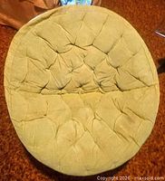 Top view of tufted beige cushion