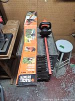 Trimmer on workbench with full 22-inch blade and original box