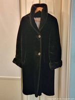 Full view of front of coat on hanger showing length, buttons, cuffs, collar