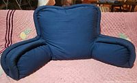 Front view of navy bedrest pillow on pink blanket