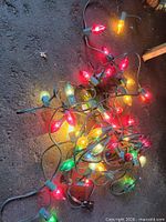 Pile of lit C9 bulbs on green wire showing working condition and color variety