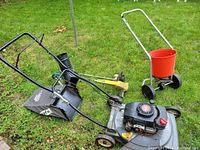 Group shot showing mower, catcher bag, string trimmer, spreader