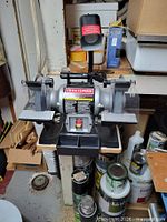 Front view showing Craftsman bench grinder, eye shields, tool rests and work light