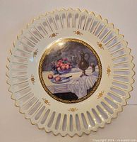 Front view showing pierced rim, gold trim and still-life center