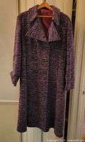 Full front view of long purple tweed double-breasted overcoat on hanger