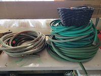 Overall lot showing two coiled hoses and basket on top