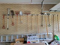 Entire row of 11 long-handled tools hung on wall