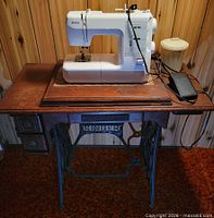Kenmore sewing machine mounted on Singer treadle cabinet